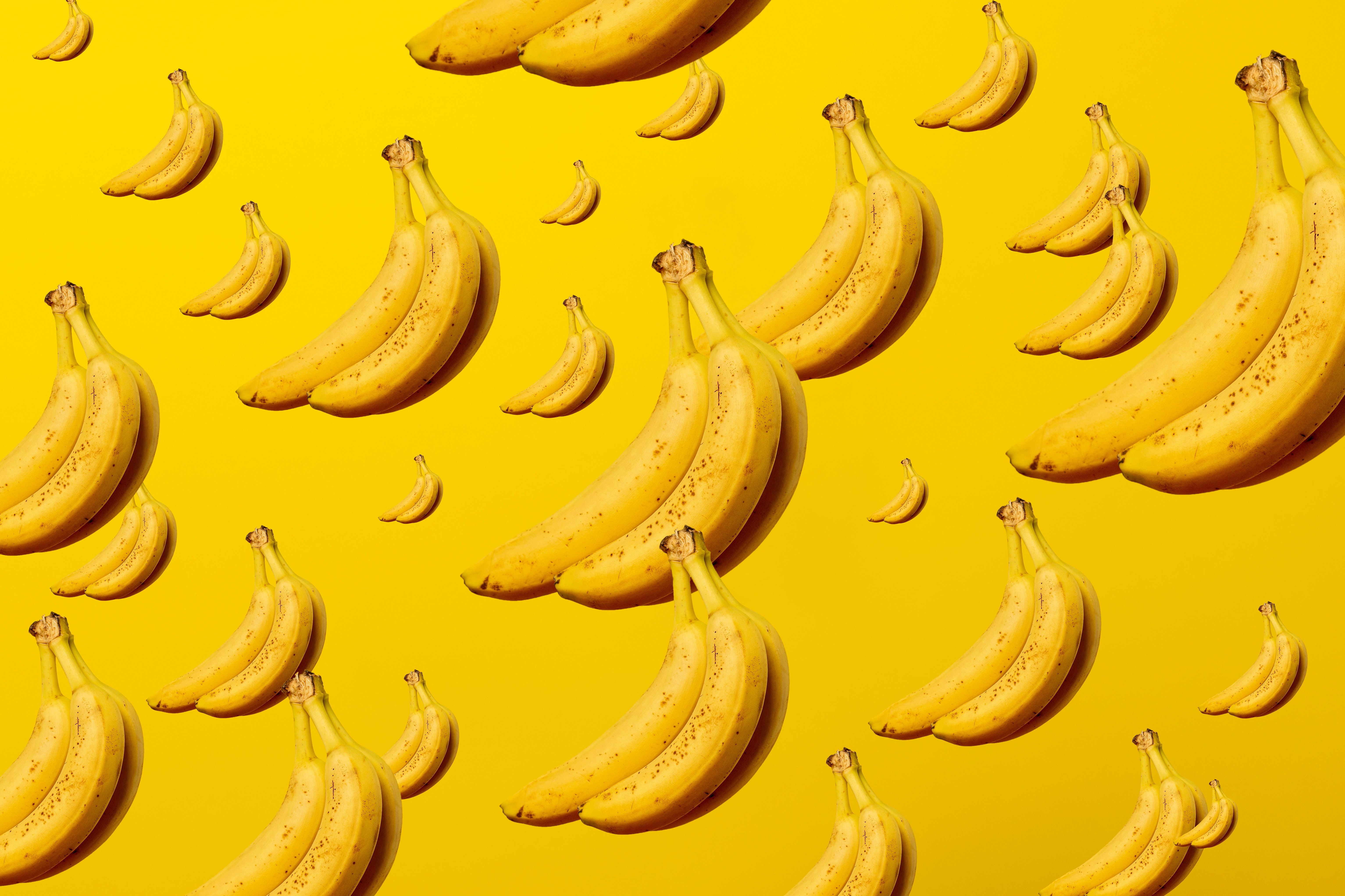 Many bunches of bananas on a yellow background